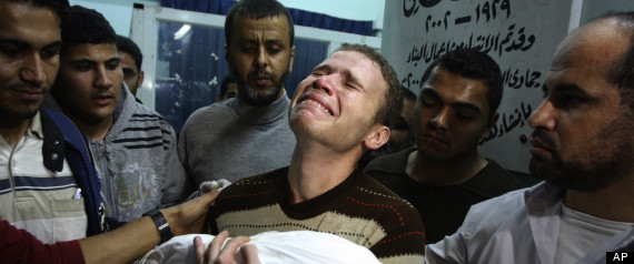FOR USE AS DESIRED, YEAR END PHOTOS - FILE - In this Nov. 14, 2012 file photo, Jihad Masharawi weeps while he holds the body of his 11-month old son Ahmad, at Shifa hospital following an Israeli air strike on their family house, in Gaza City. The Israeli military said its assassination of the Hamas military commander Ahmed Jabari, marks the beginning of an operation against Gaza militants. (AP Photo/Majed Hamdan, File)